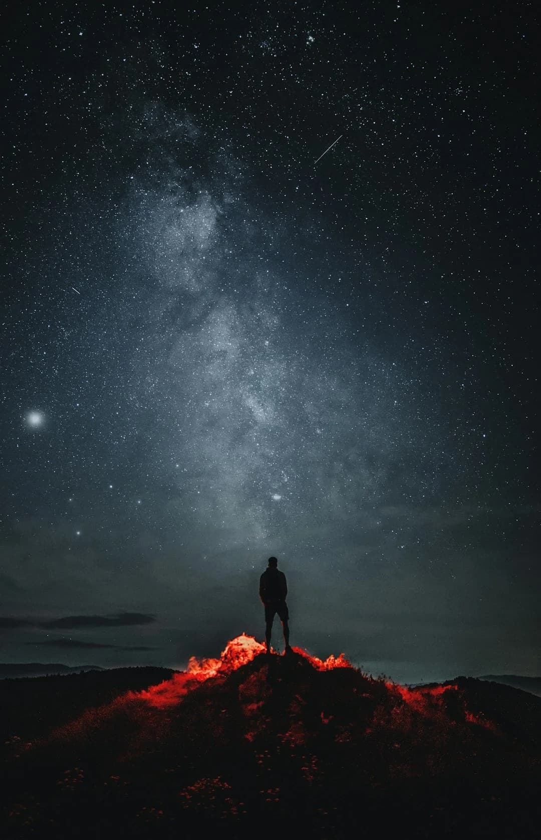 Creator beneath a dramatic night sky